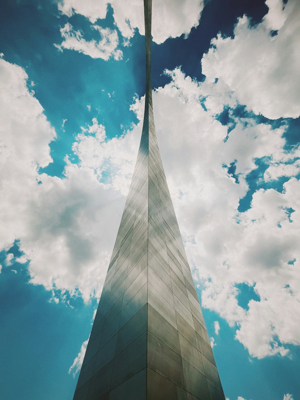 a tall building with clouds in the sky