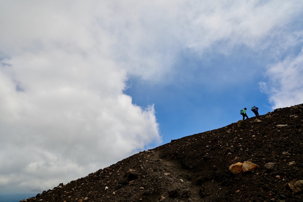 a couple people hiking up a mountain