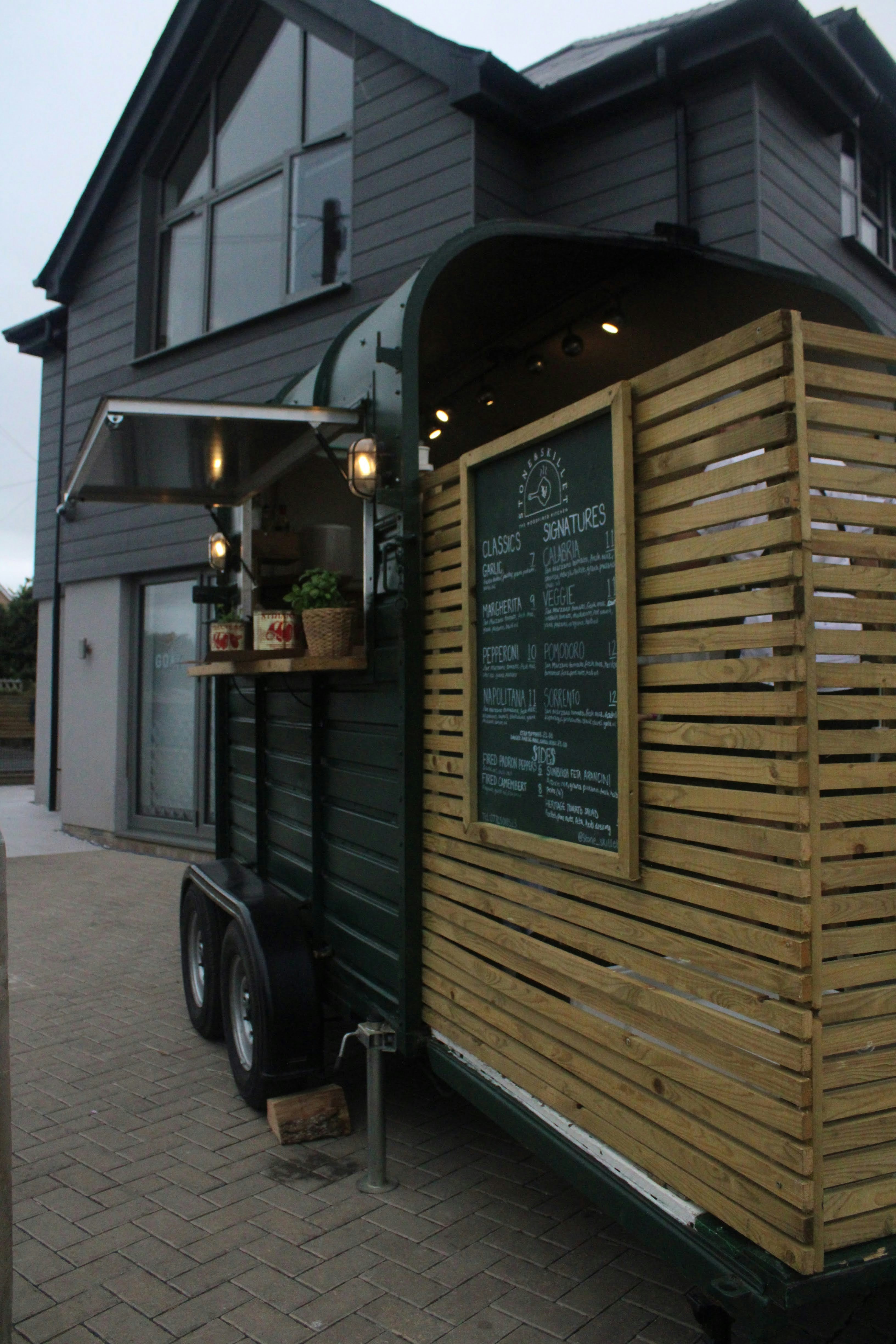 a wooden trailer parked outside a building