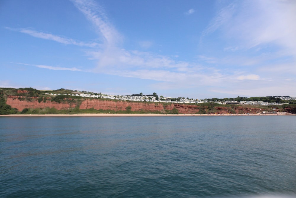 a body of water with a hill in the background