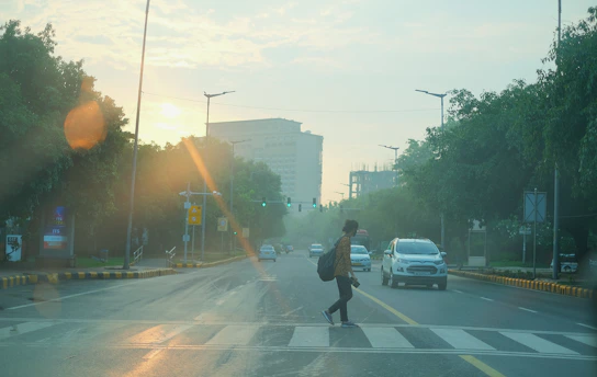 Runner crossing a city street at dawn, with soft morning light and empty roads.