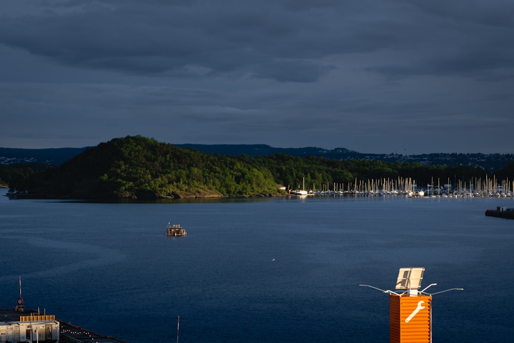 a body of water with boats and a hill in the background