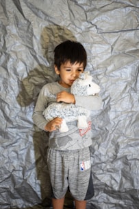 a child holding a stuffed animal
