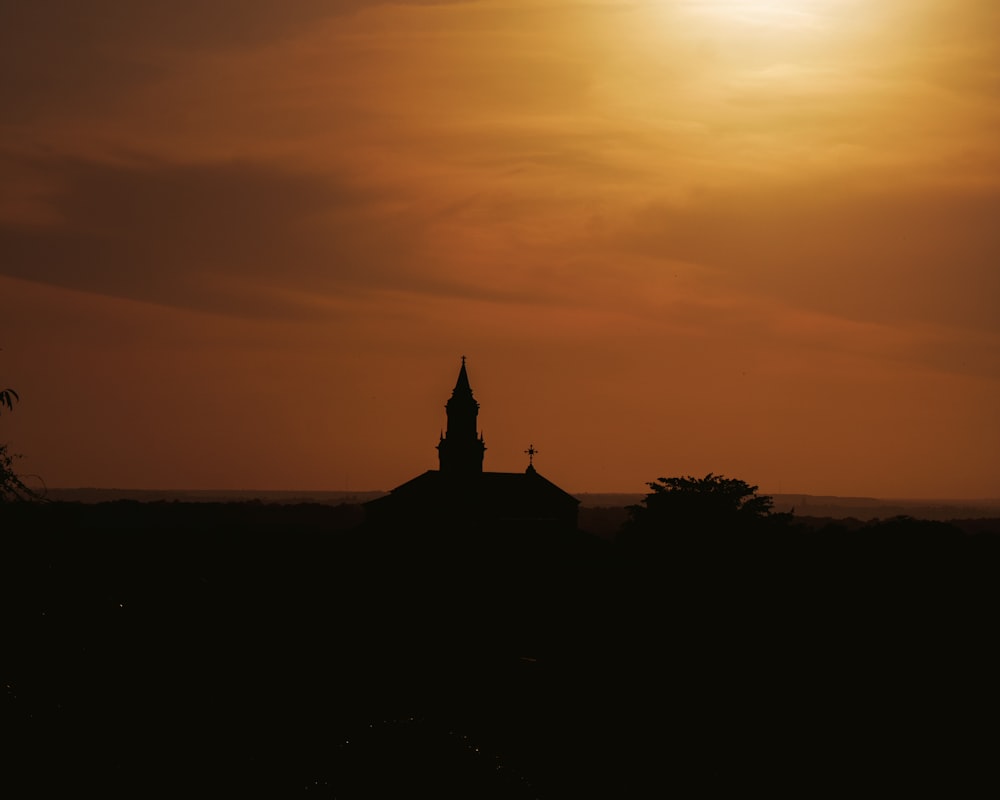 a silhouette of a building and a sunset