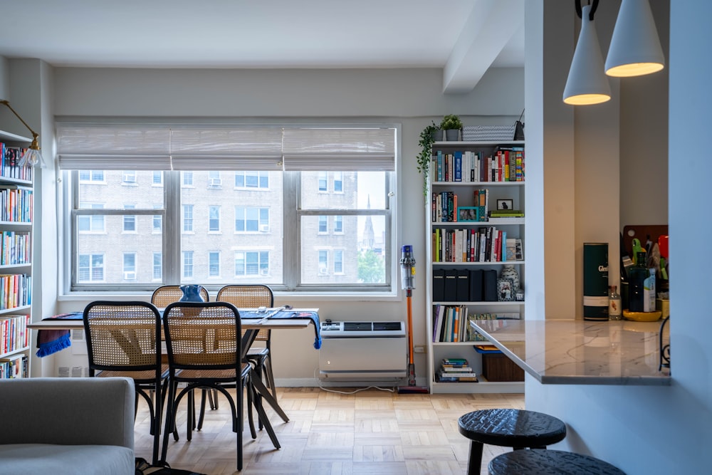 a room with a table chairs and a bookcase