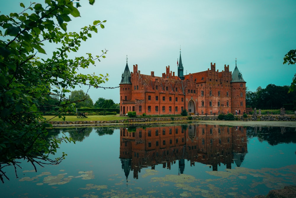 a large building with towers by a body of water