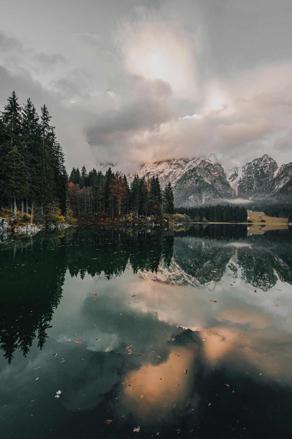 a lake with trees and mountains in the background