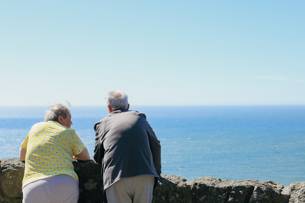 a couple of people looking at the ocean