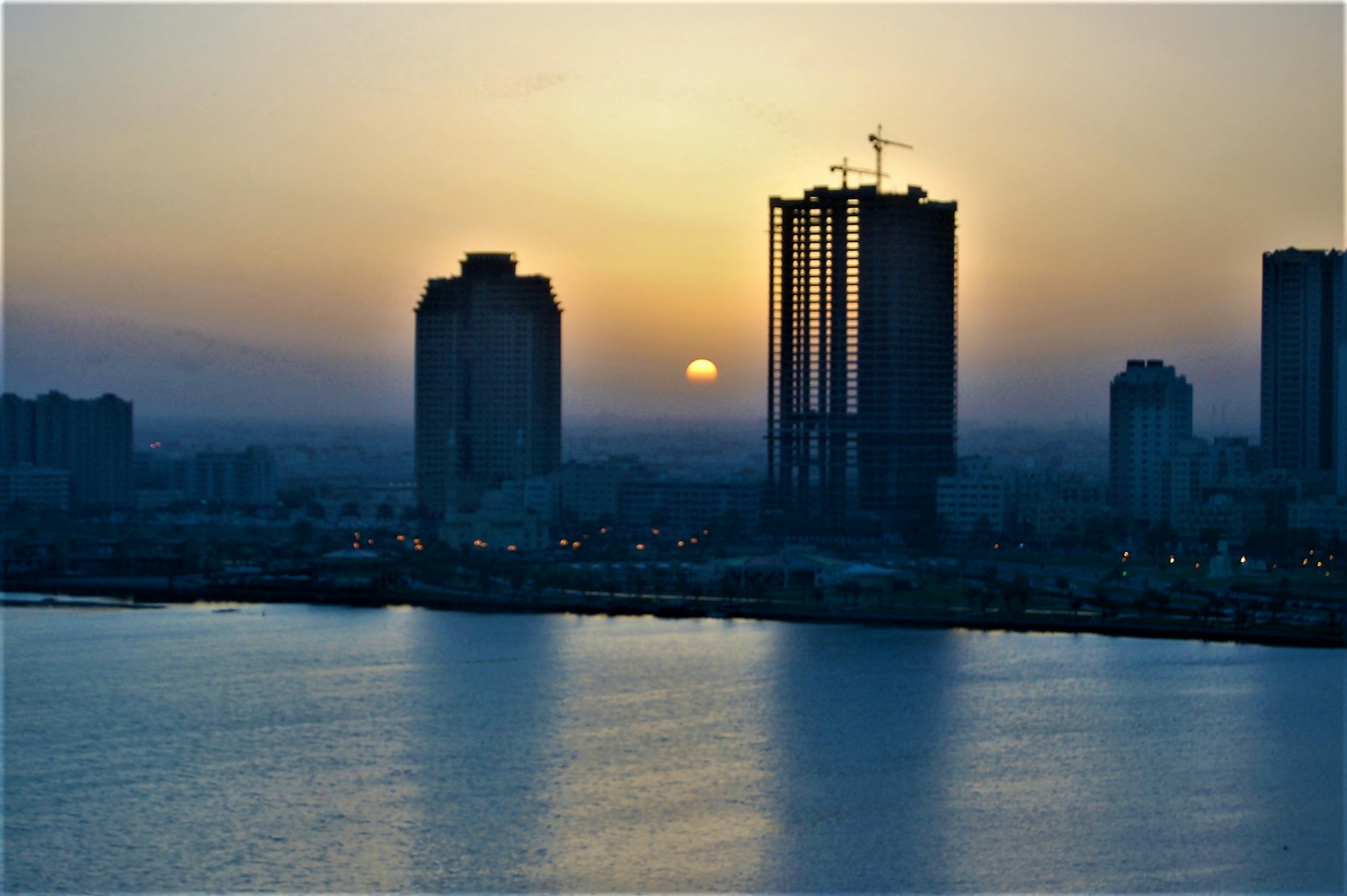 a city skyline with the sun setting