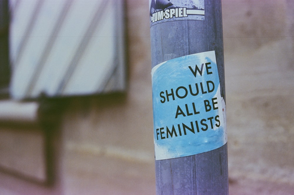 a blue and white sign on a pole