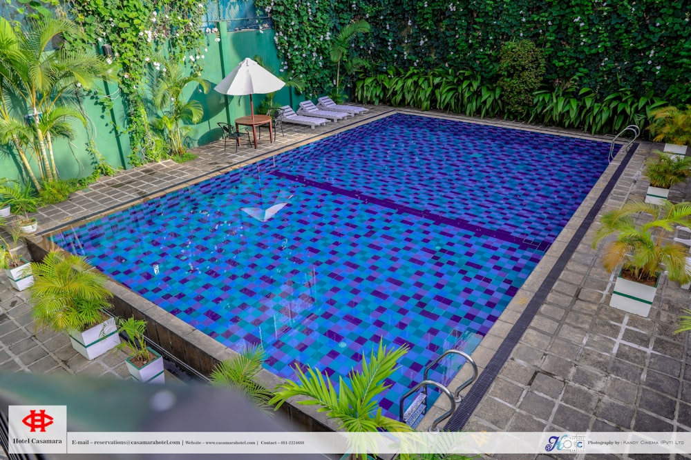 una piscina con una superficie de azulejos azules y blancos