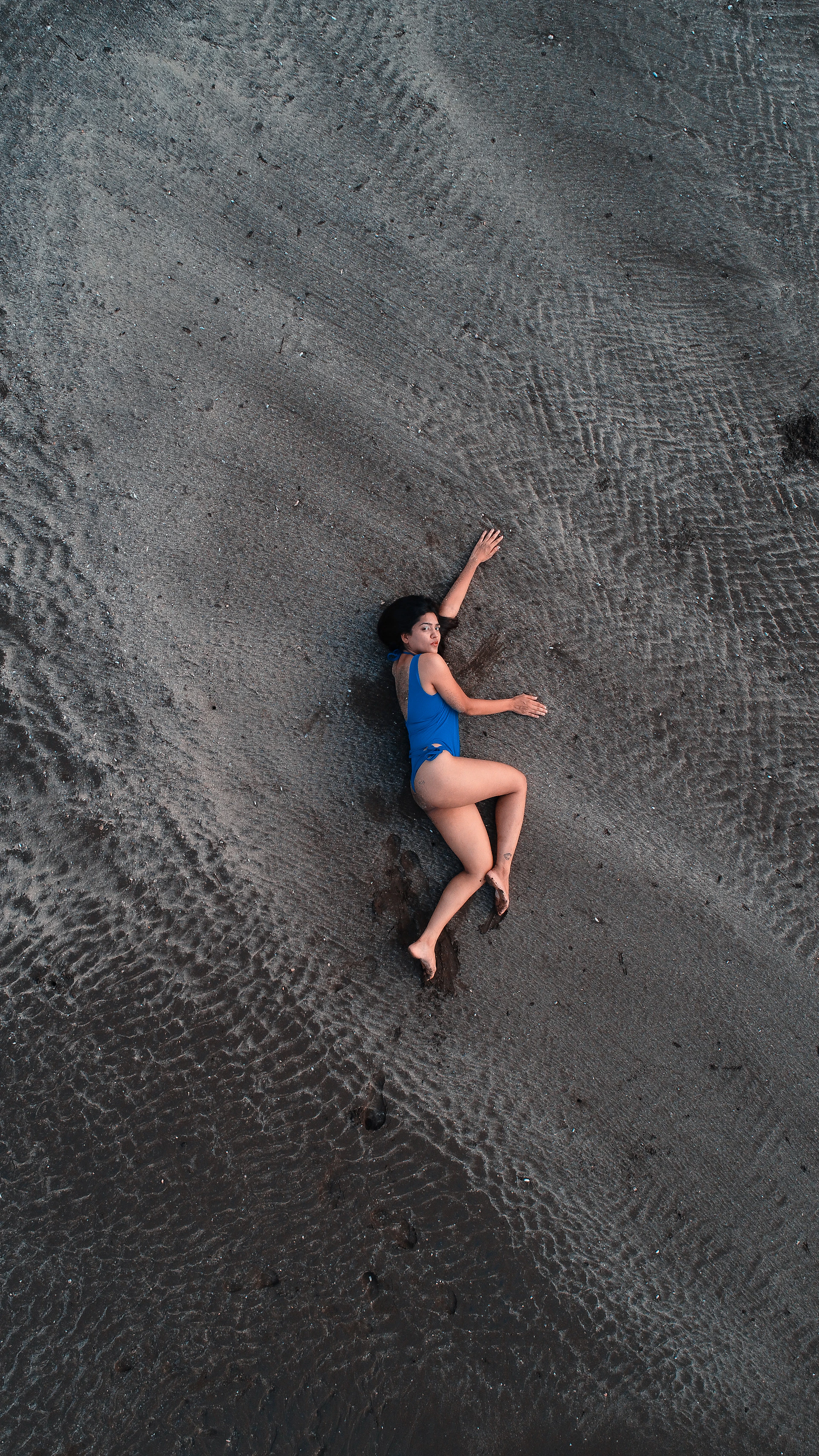 a person in a blue dress sitting on a rock