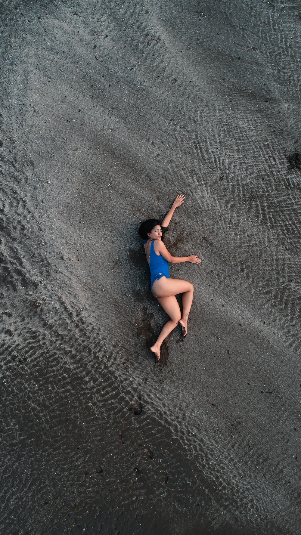 a person in a blue dress sitting on a rock