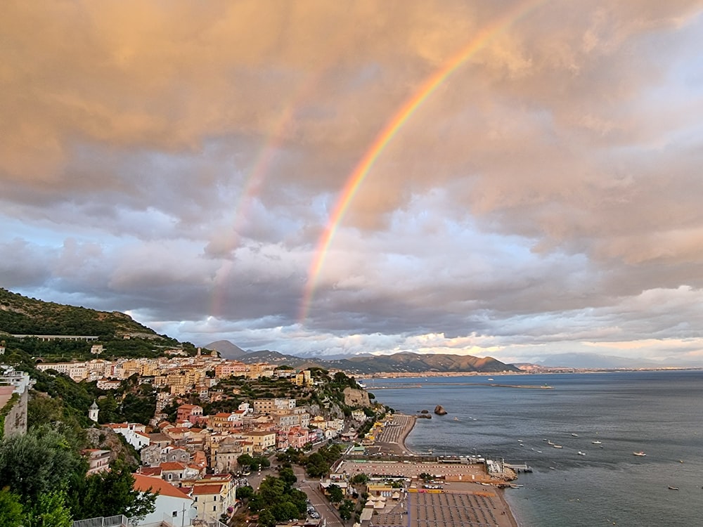 a rainbow over a city by the water