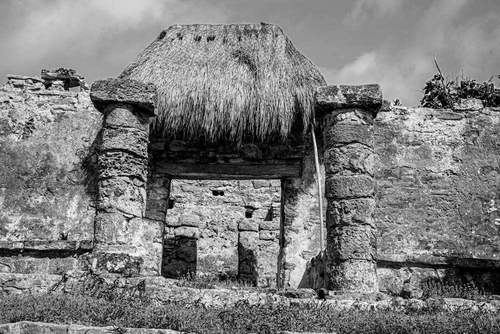 a stone building with a straw roof