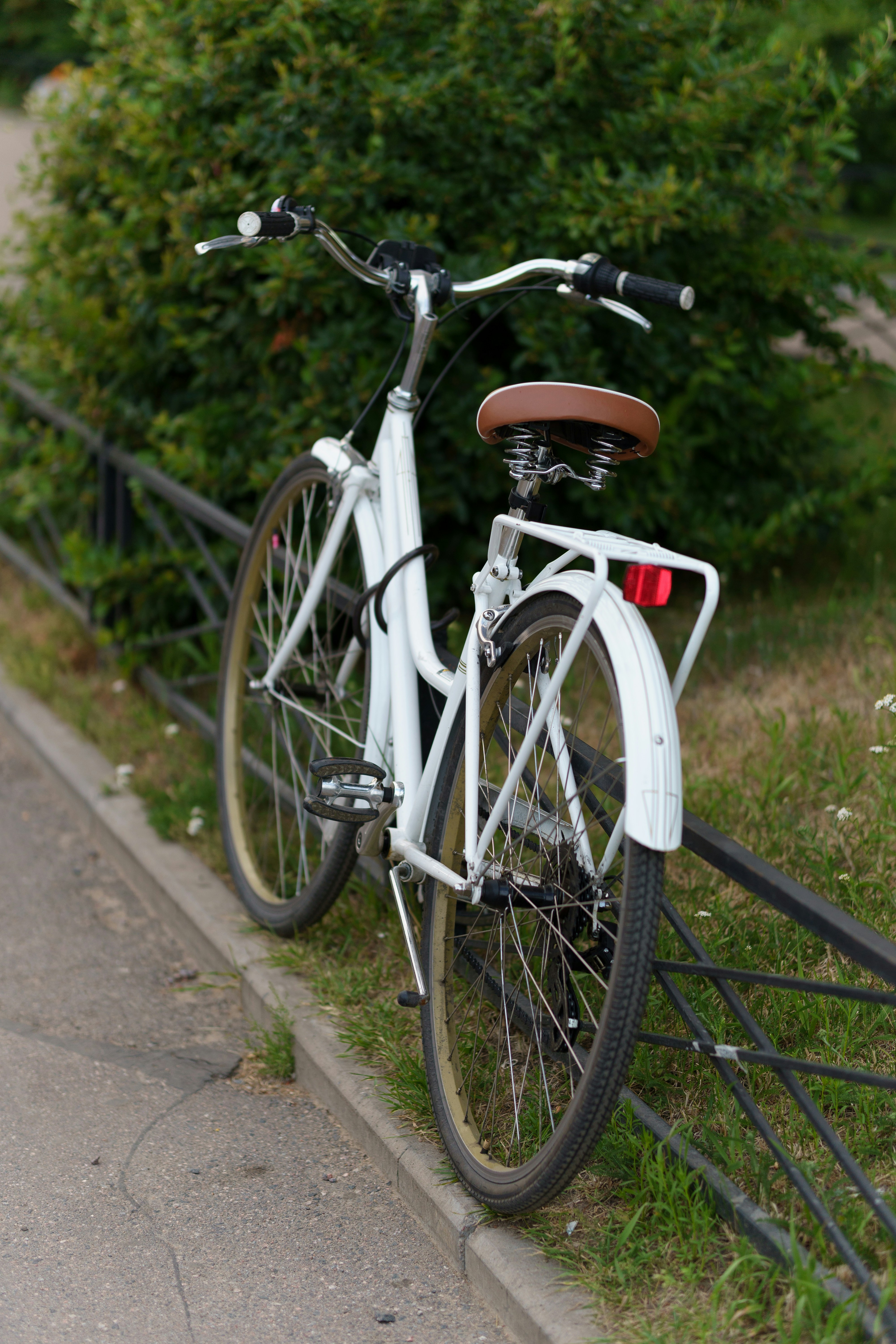 a white bicycle parked on a fence