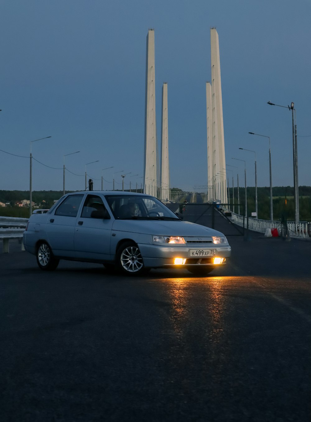 a car on a road with tall pillars in the background