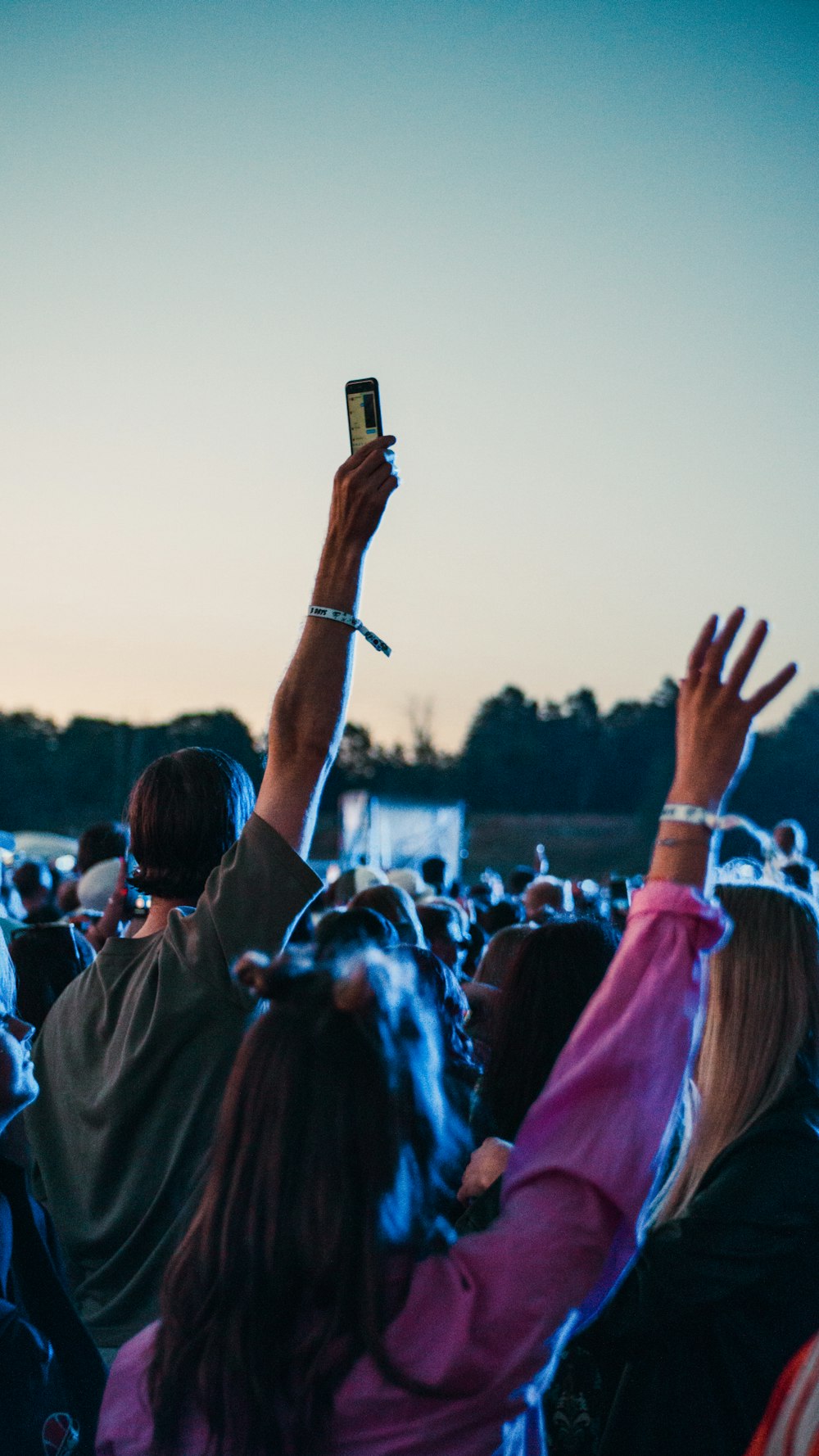 a crowd of people holding up their hands