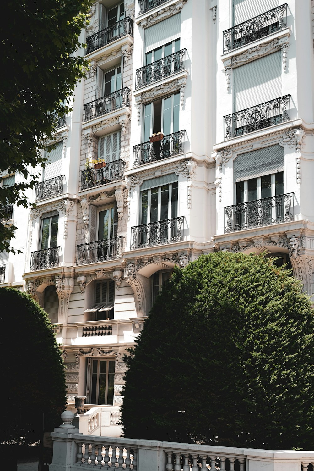 a building with balconies and trees in front of it