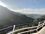 Balcony view overlooking serene mountain landscape under a clear blue sky.