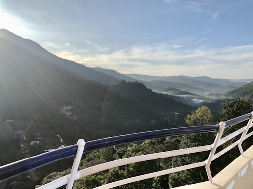 A serene view of the homestay's cozy porch overlooking misty Himalayan mountains at dawn.