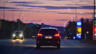 Happy driver checking fuel prices on prețviu before starting a road trip