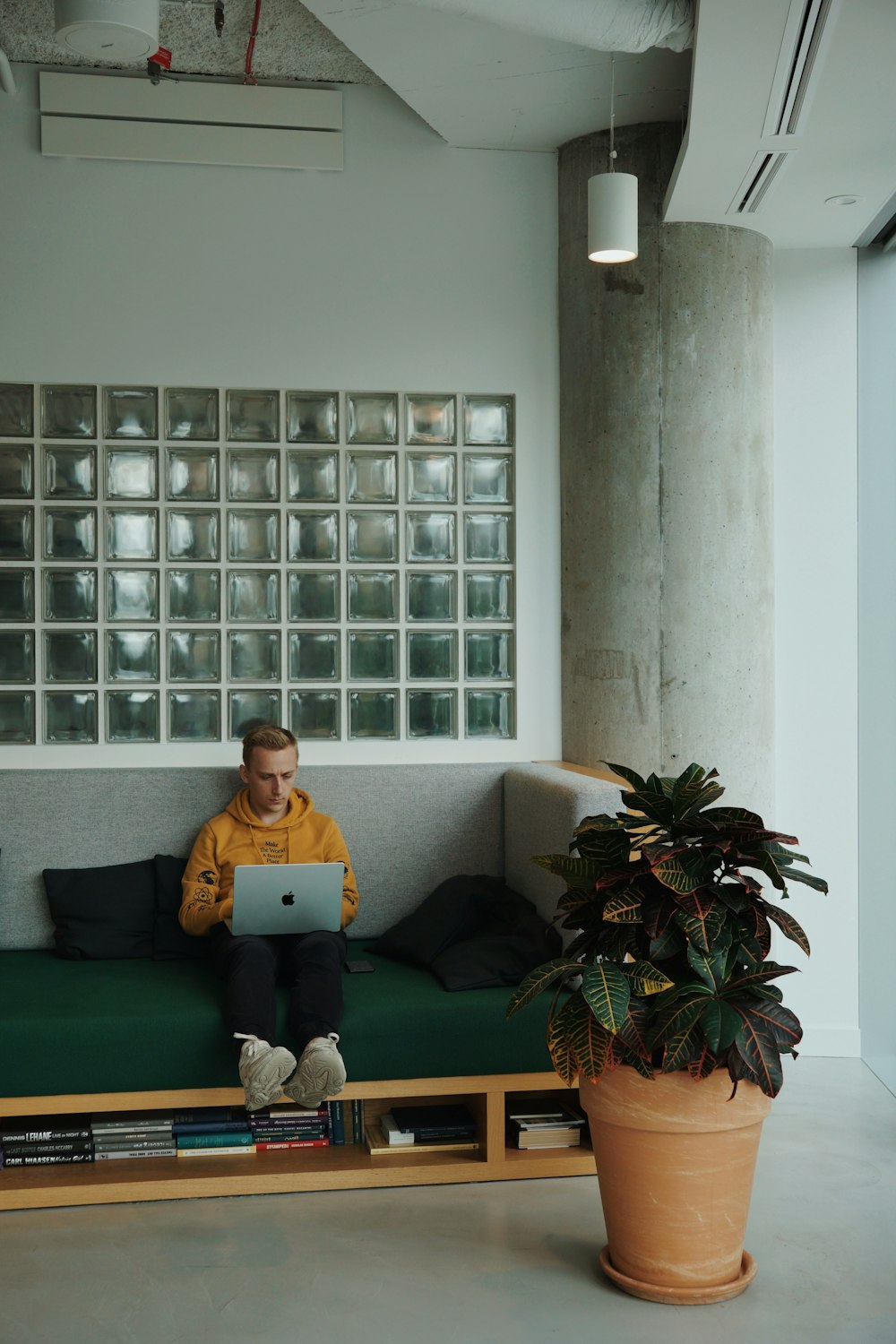 a boy sitting on a couch with a laptop