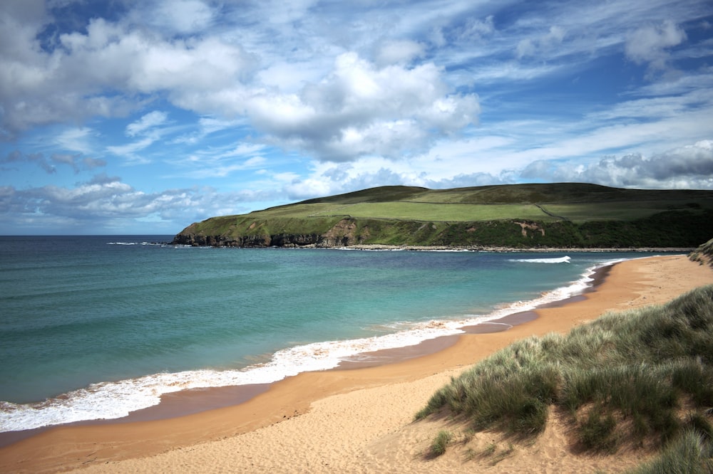 a beach with a hill in the background