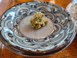 Artistic ceramic plate with openwork edges and a glossy emerald finish.