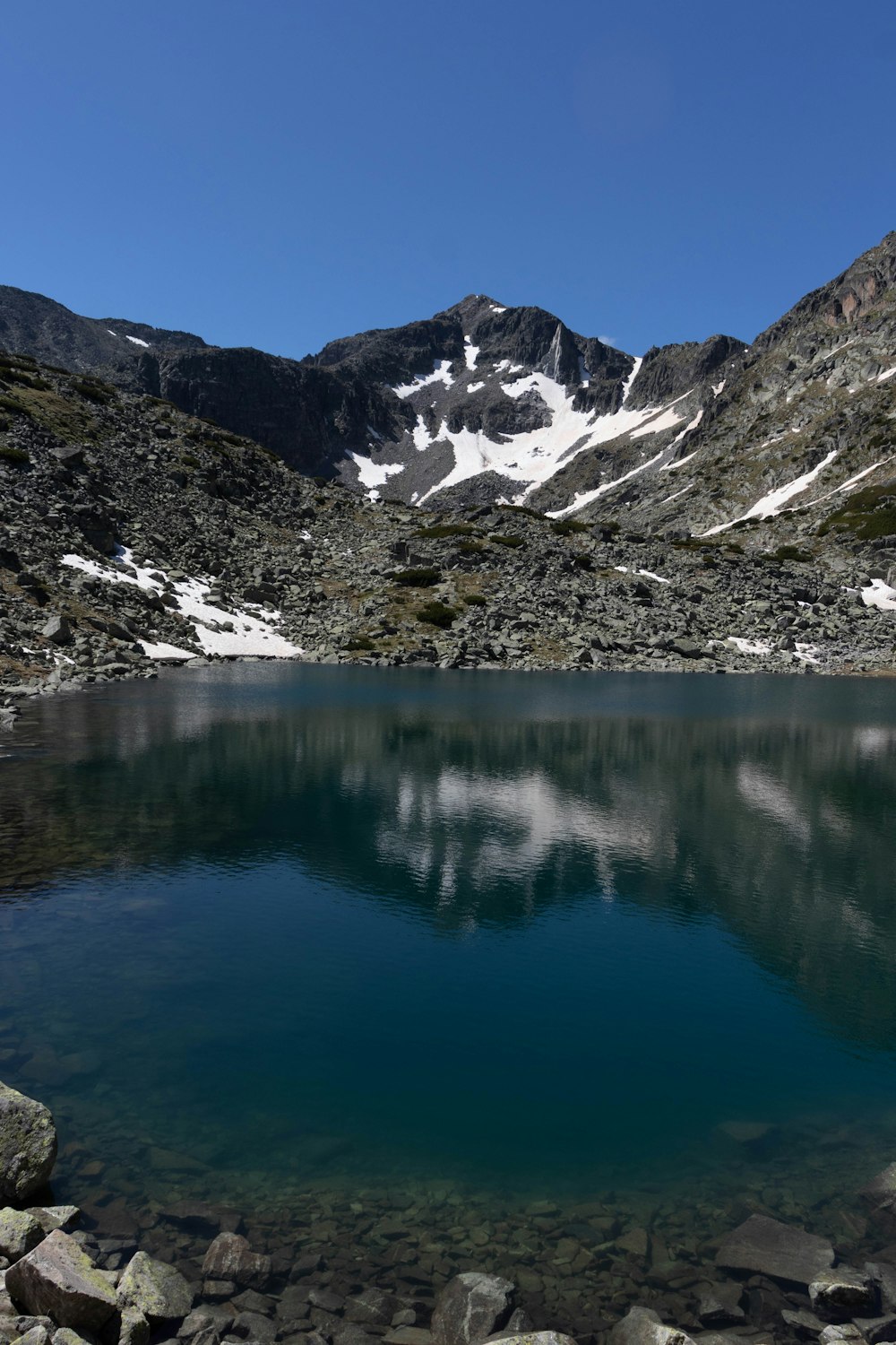 a lake with snowy mountains in the background