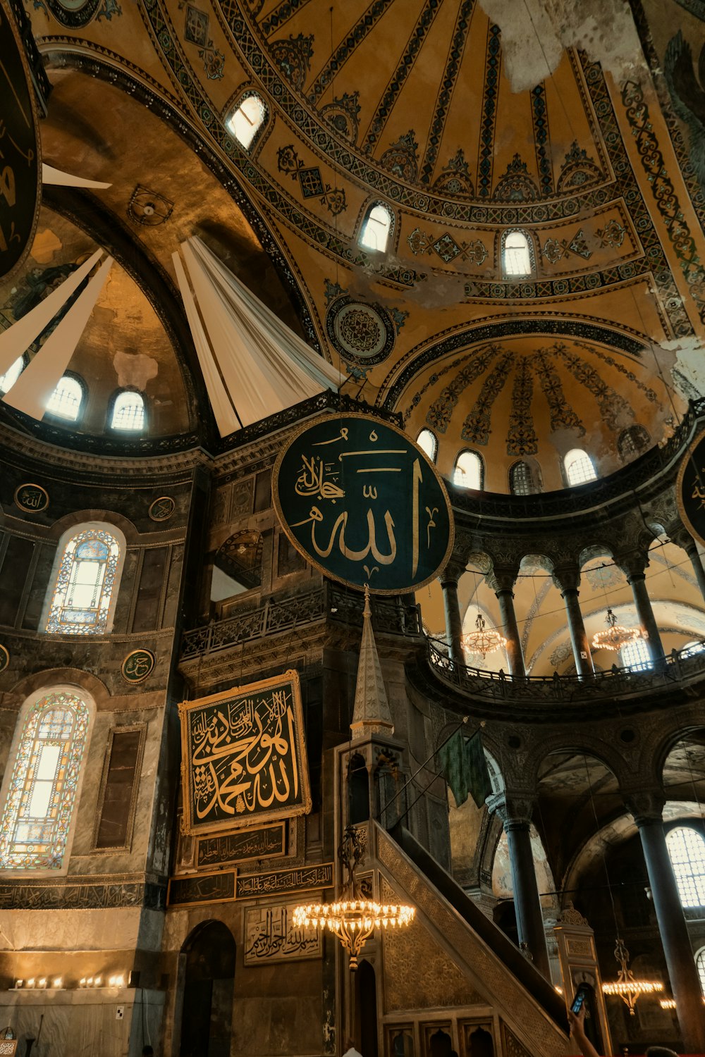 a large ornate ceiling with a sign with Hagia Sophia in the background