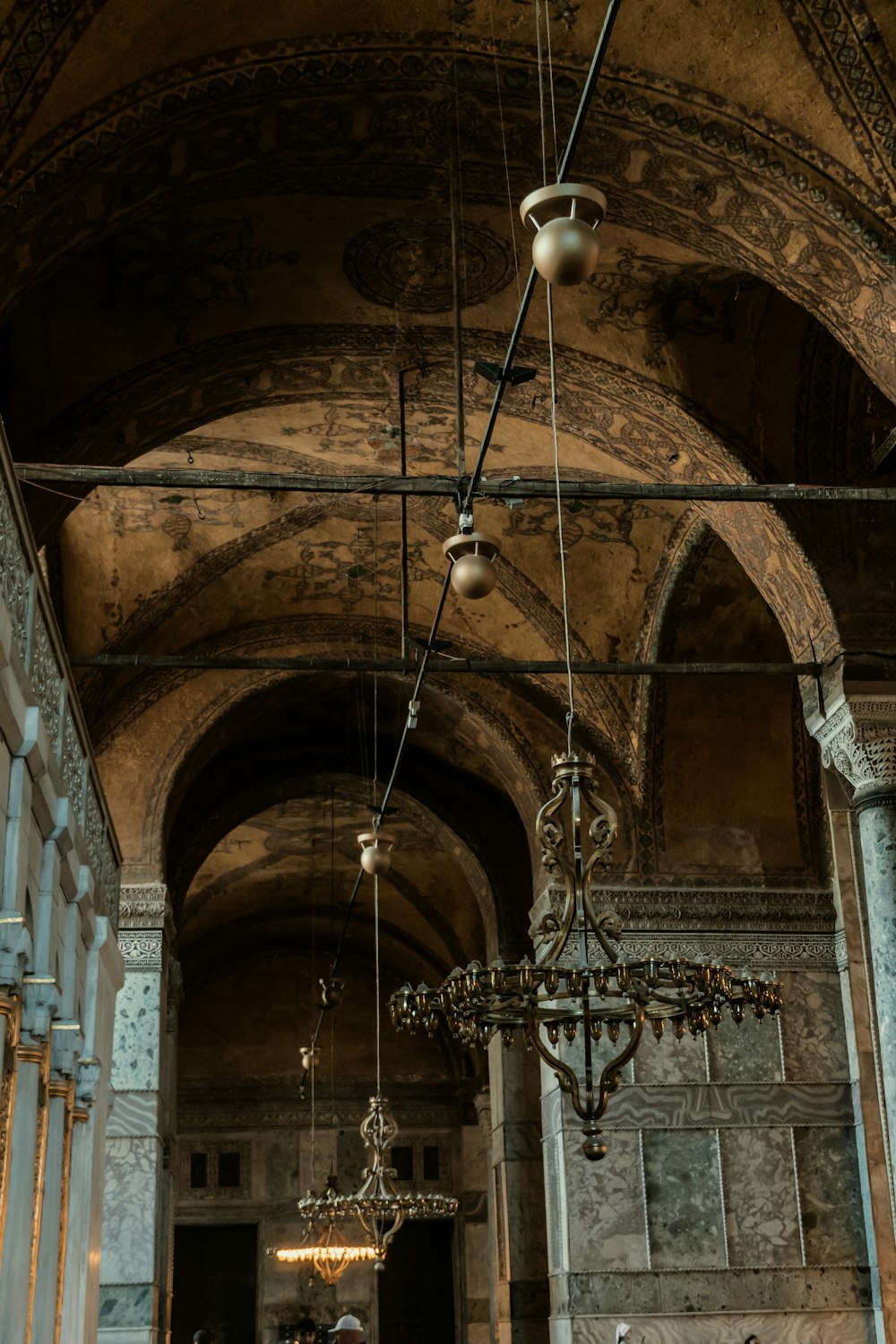 a large arched ceiling with a chandelier and a large arched window