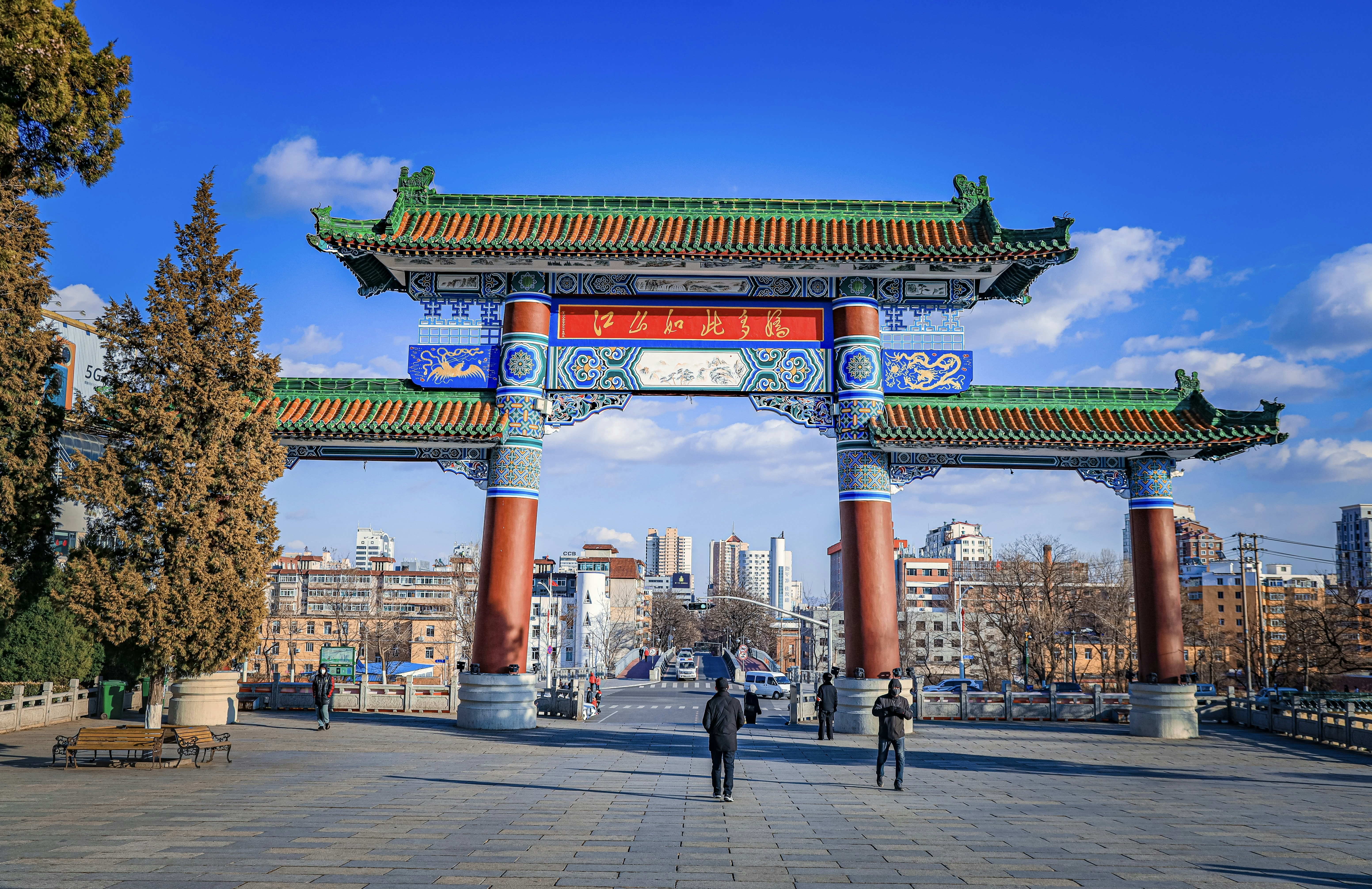 a large red and yellow arch with people walking underneath