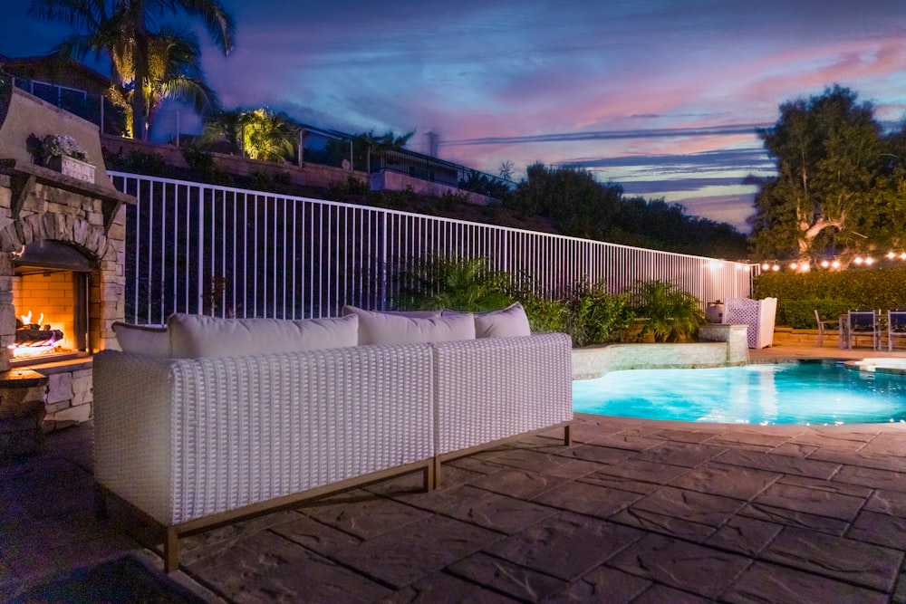 a patio with a pool and a deck with a house in the background