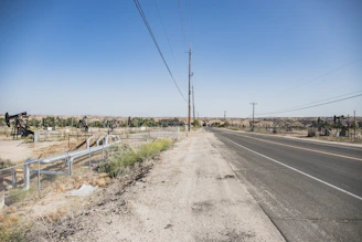 A field agent discussing with landowners near a Texas oil pipeline under the wide, open sky.