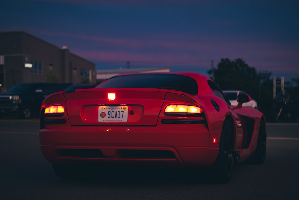 a red sports car with its headlights on