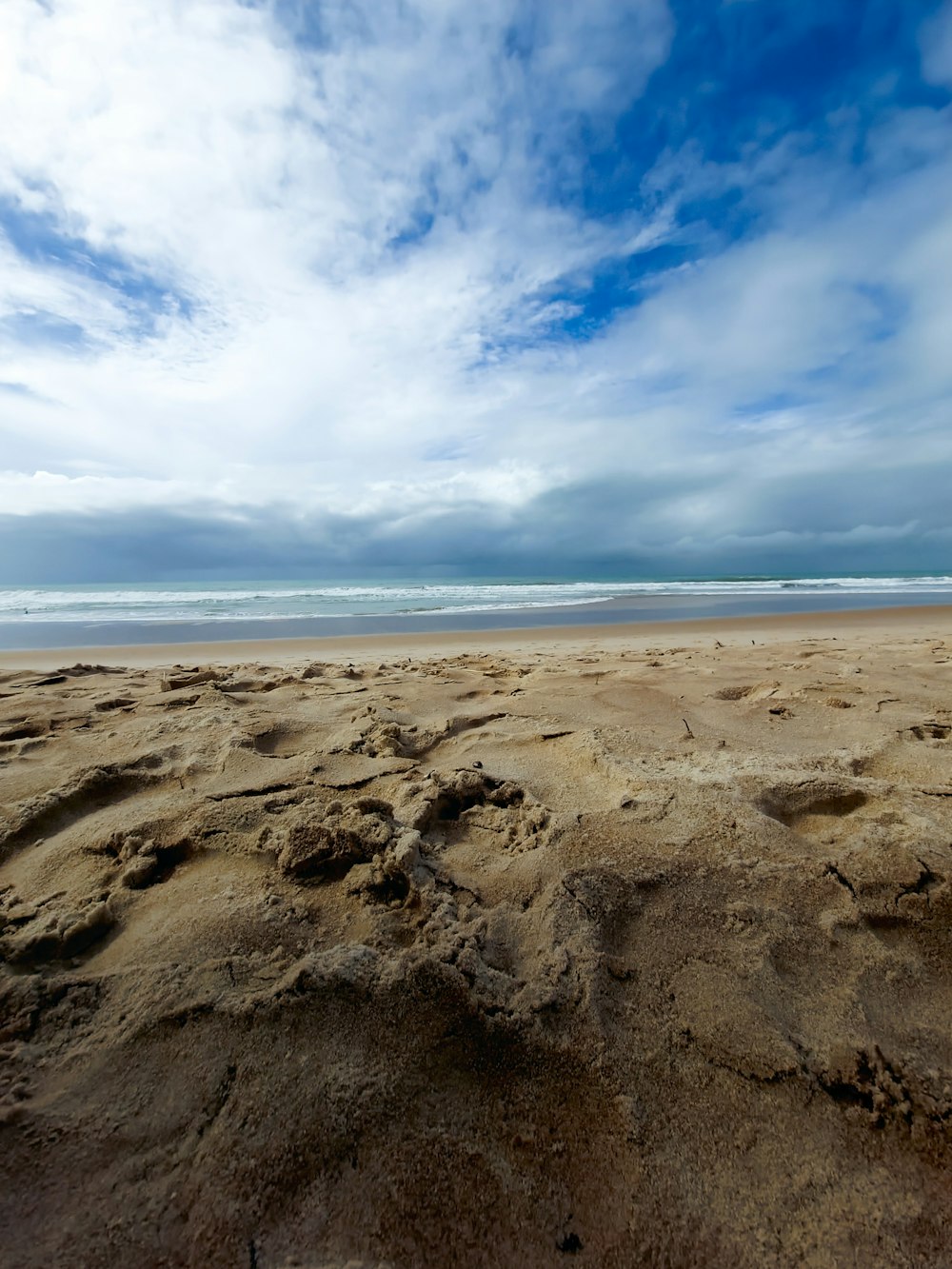 a sandy beach with a cloudy sky
