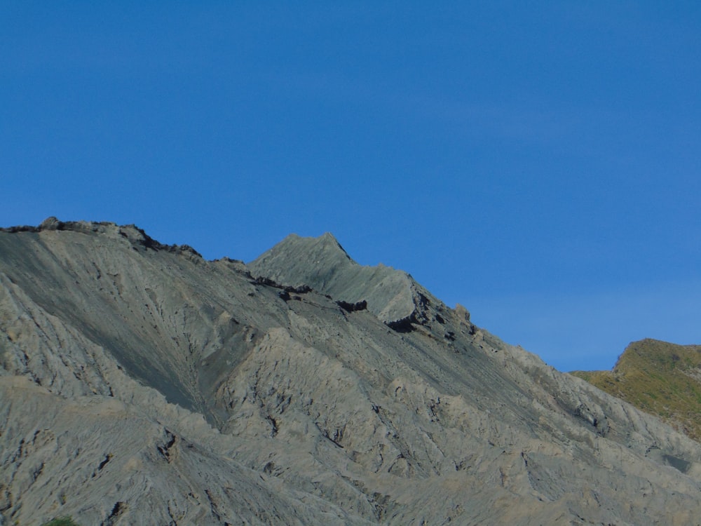 a rocky mountain with a blue sky