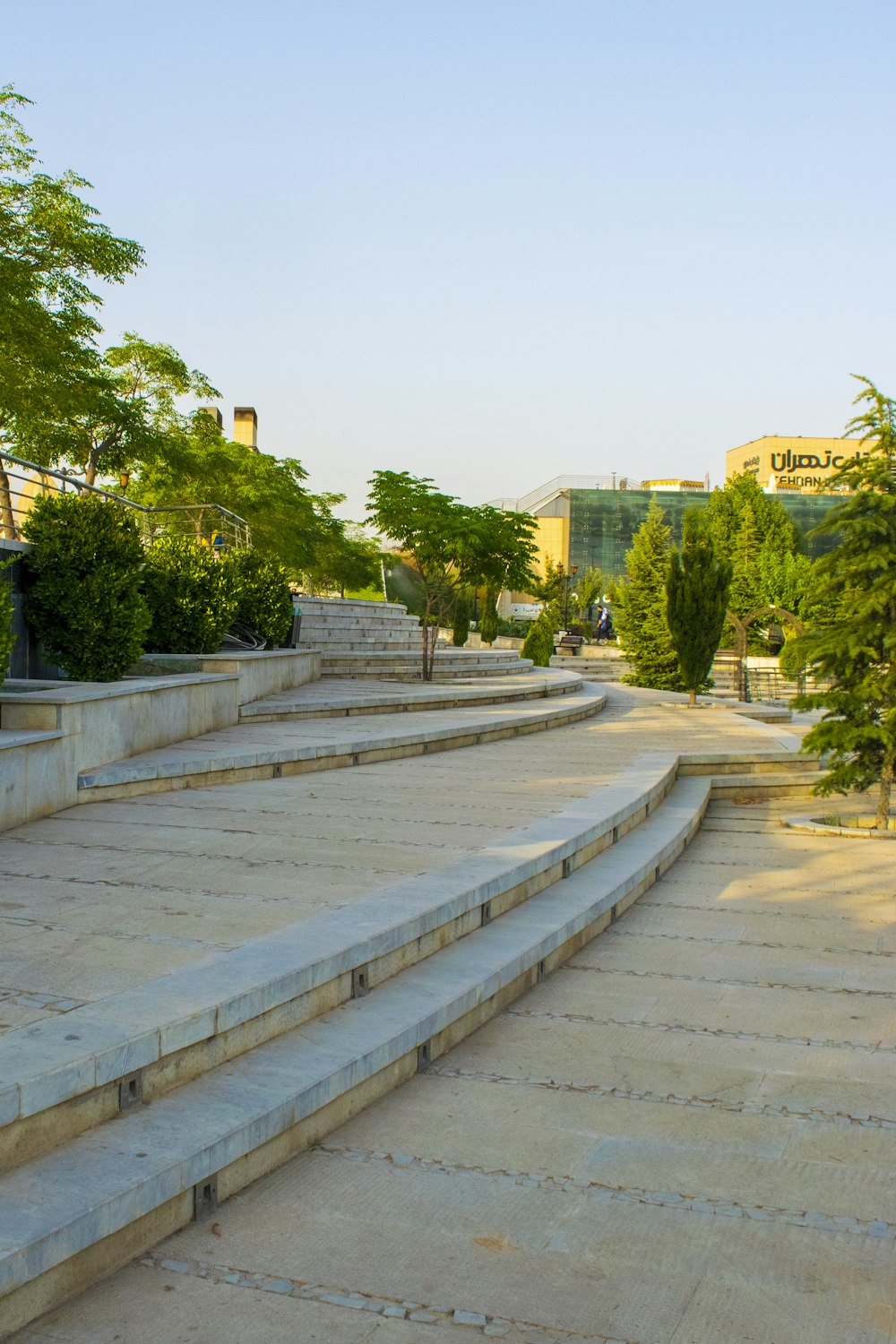 a stone walkway with trees and buildings