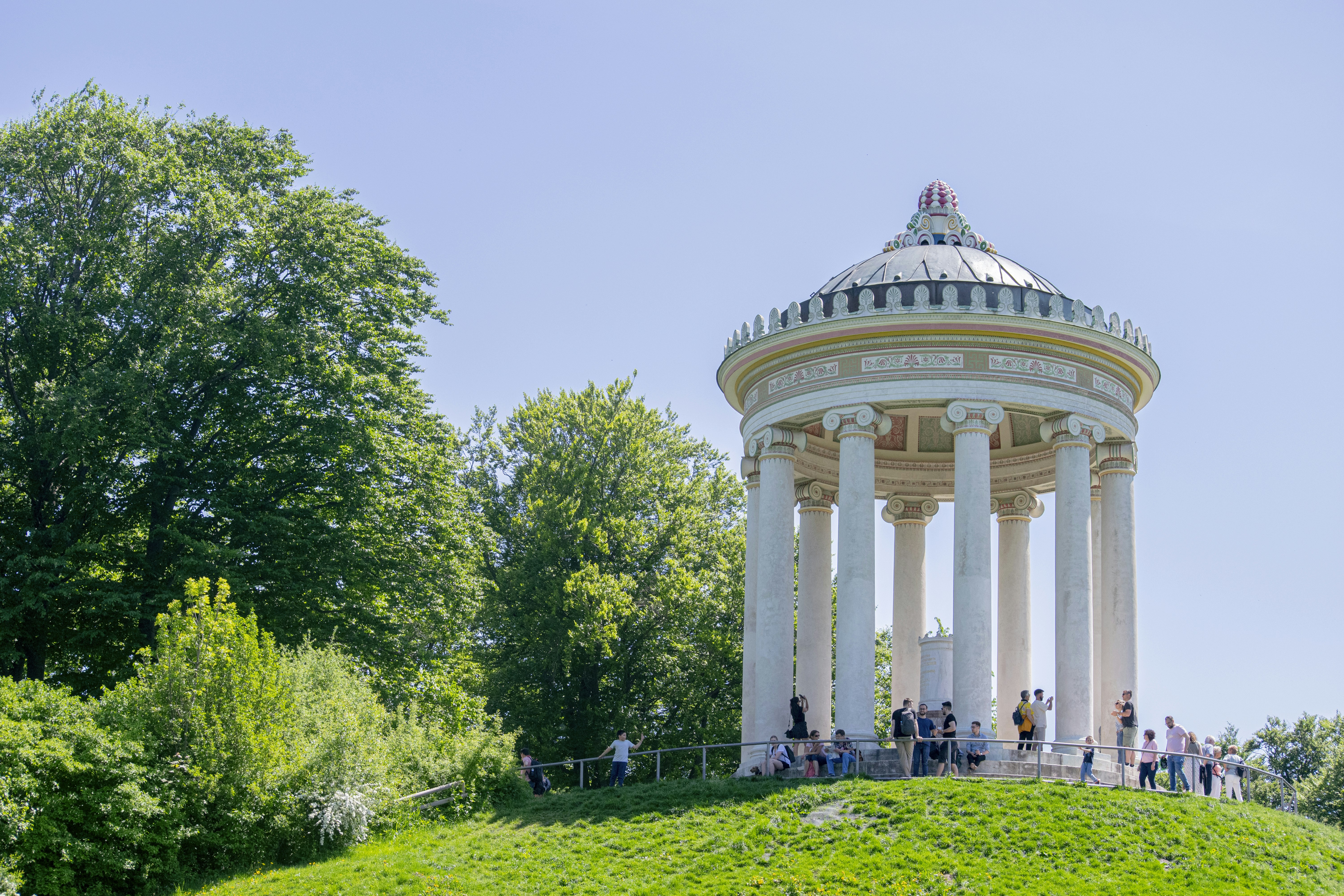 a group of people standing outside a building with columns