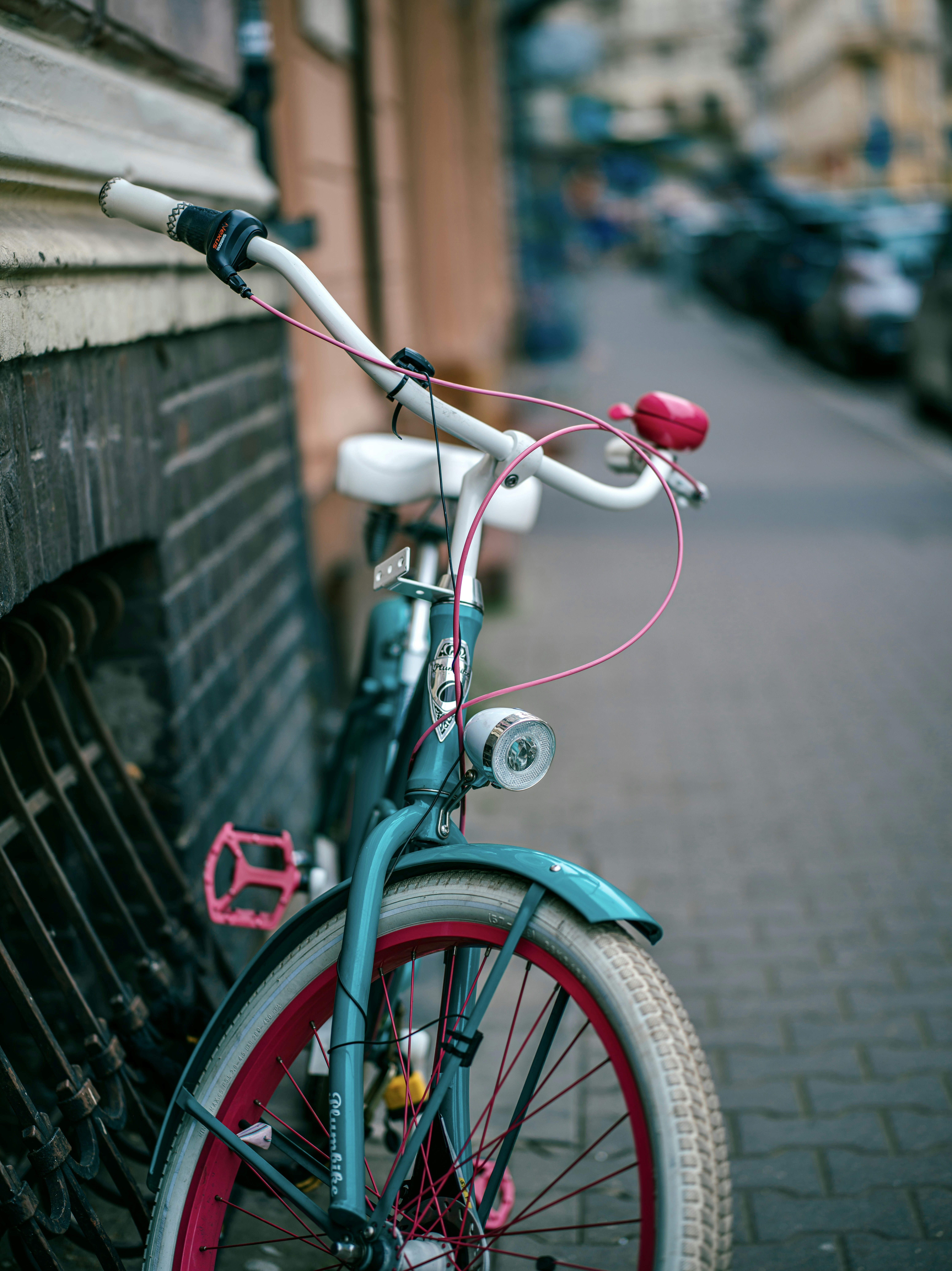 a pink bicycle parked on a sidewalk