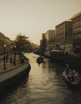 a small boat in a body of water with a city in the background