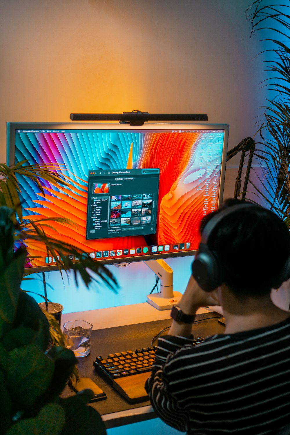 a person wearing headphones and sitting at a desk with a computer