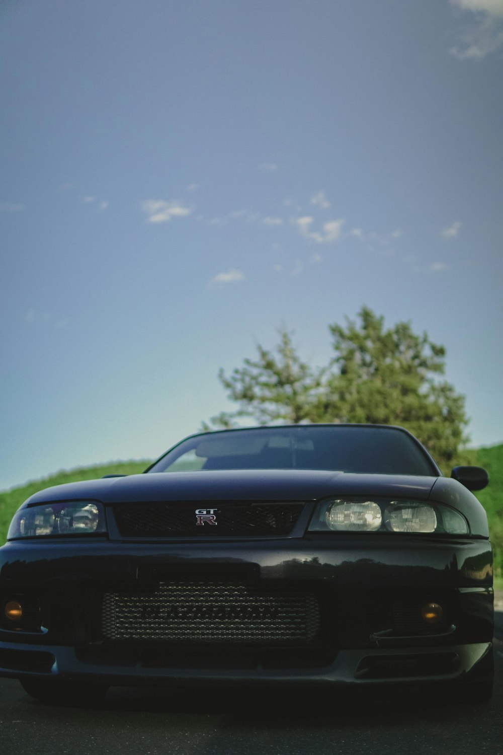 a black car with a tree in the background