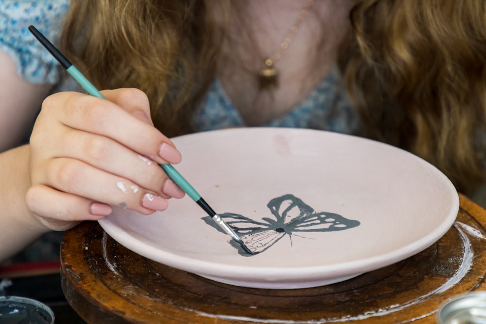 uma criança pintando uma tigela