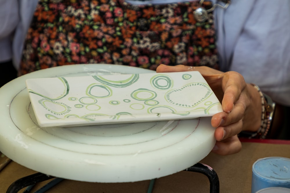 a person holding a white plate