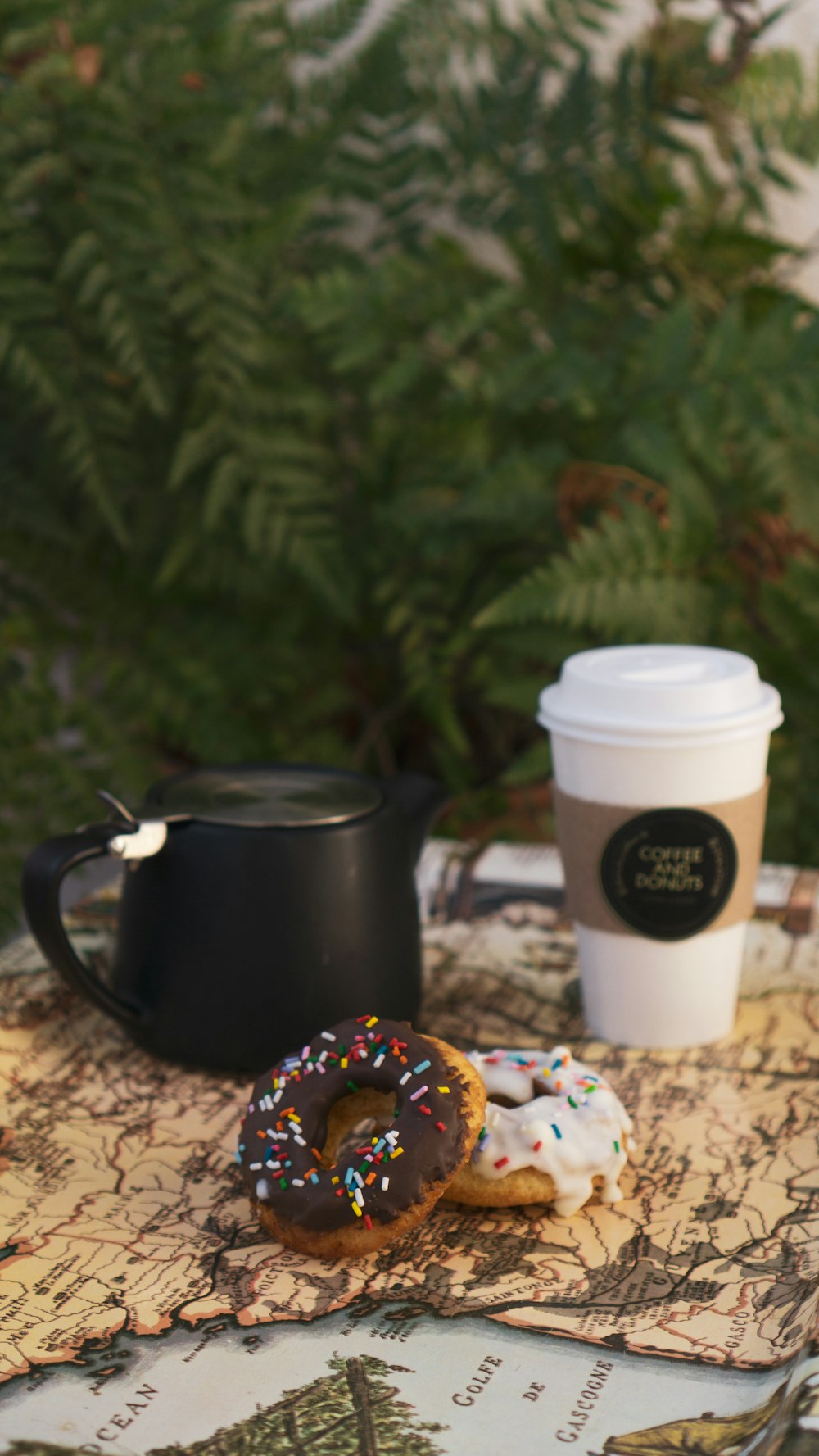 a coffee cup and a couple of donuts on a table