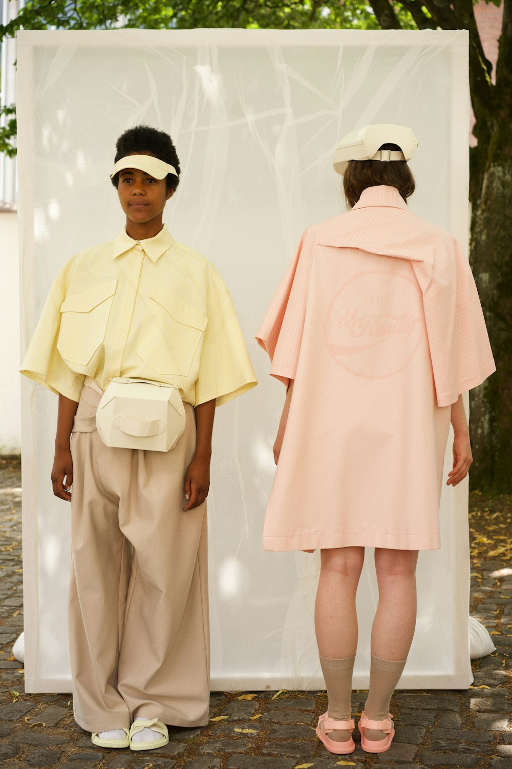 a man and woman standing next to each other in front of a white tent