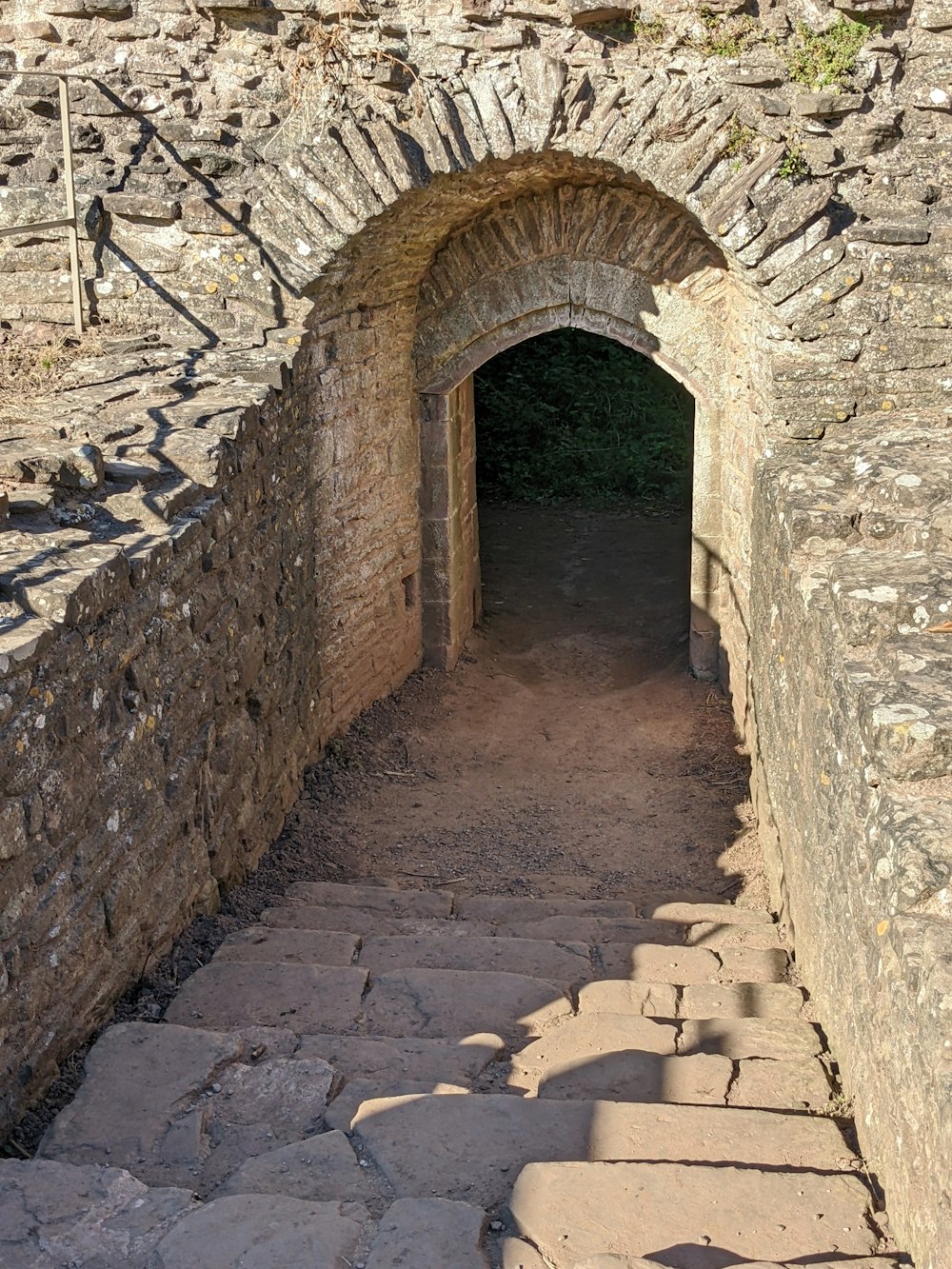 a stone walkway with a stone archway