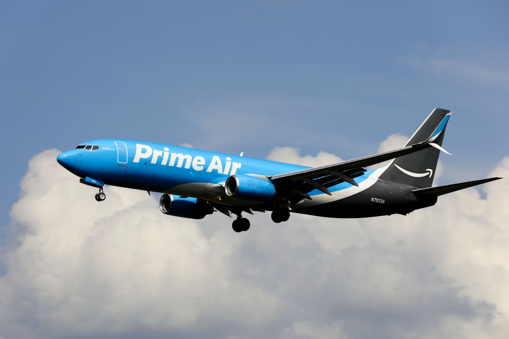 a blue and white airplane flying in the sky